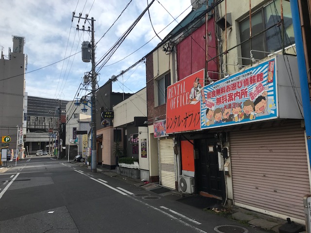 五井（西口商店街）クラブの大看板。飲食店や風俗店が密集する繁華街。 – 古今東西舎